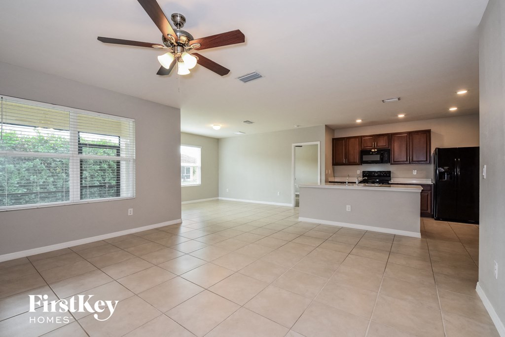 an empty kitchen and living room with a ceiling fan