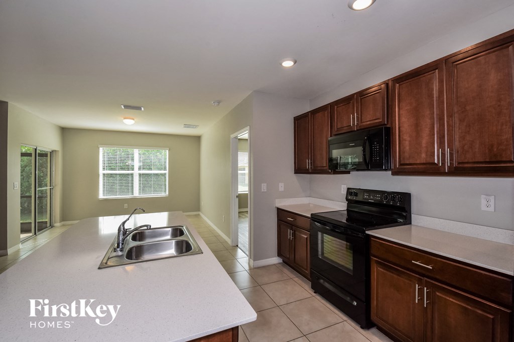 full view of kitchen with black appliances and white countertops