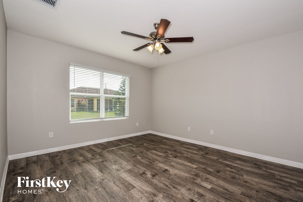 the living room with wood floors and a ceiling fan