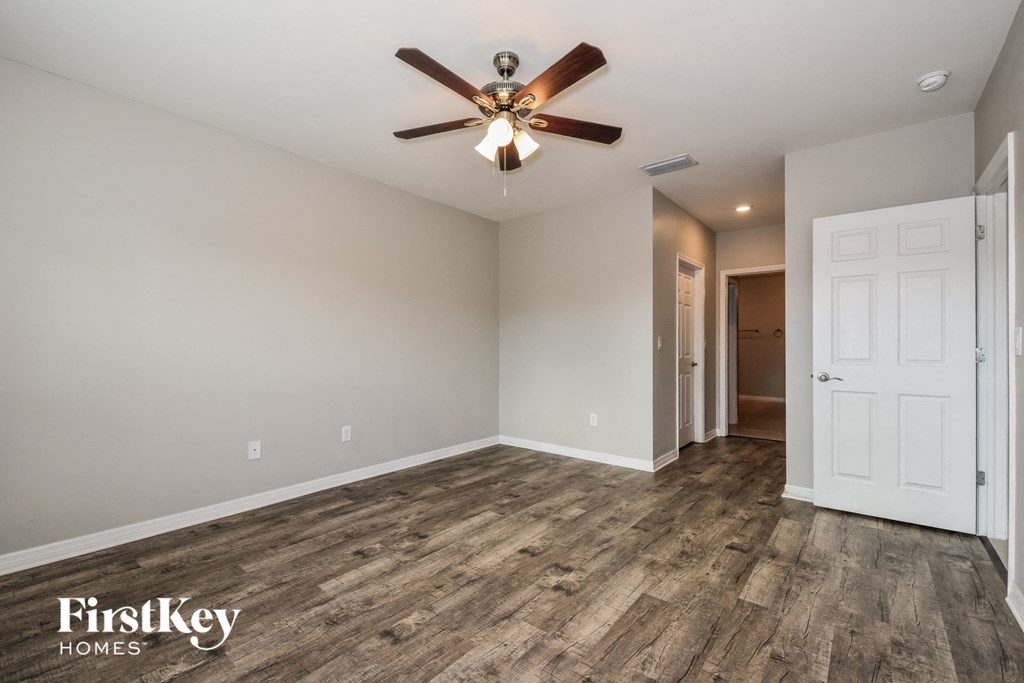 the great room with hardwood flooring and a ceiling fan