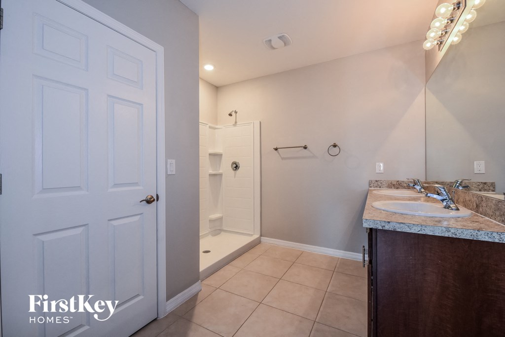 a bathroom with a sink and a mirror and a shower