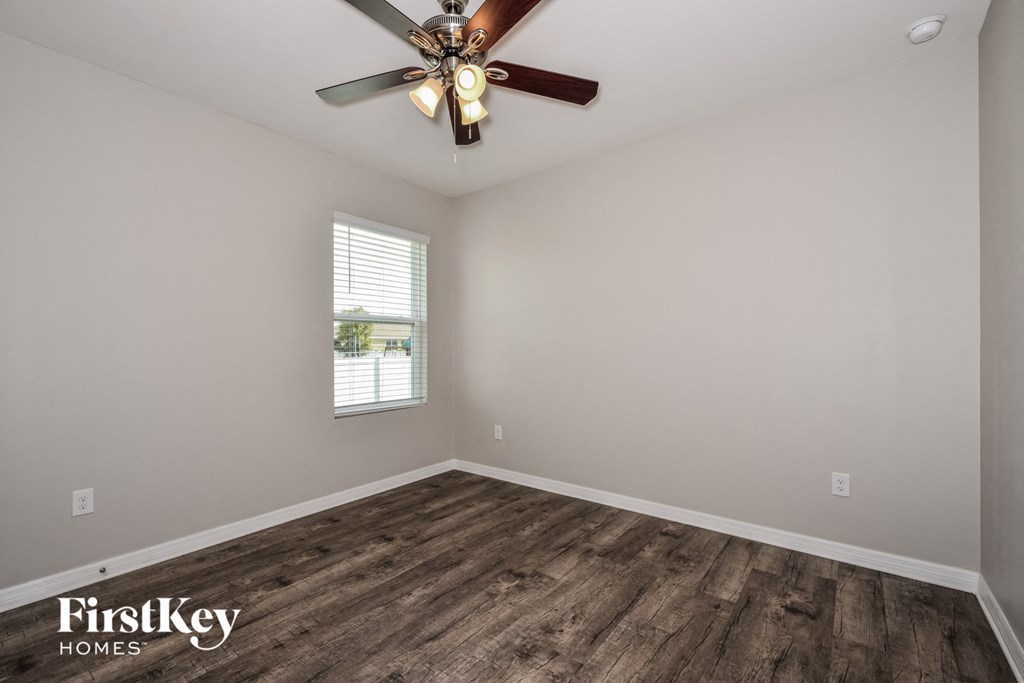 the great room with wood flooring and a ceiling fan