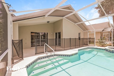 A pool in a house with a glass wall.