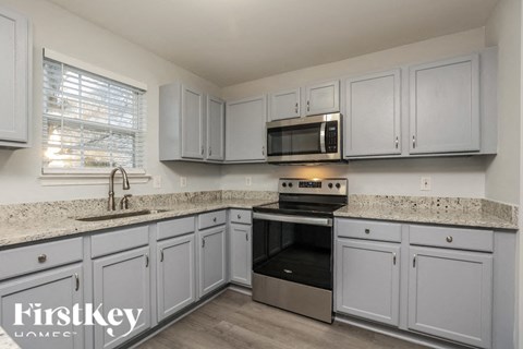 A kitchen with a stove top oven and a microwave above it.
