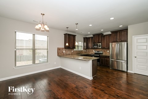 a kitchen with a large island and a stainless steel refrigerator