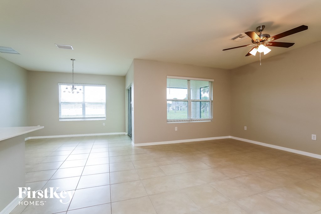 an empty living room with a ceiling fan