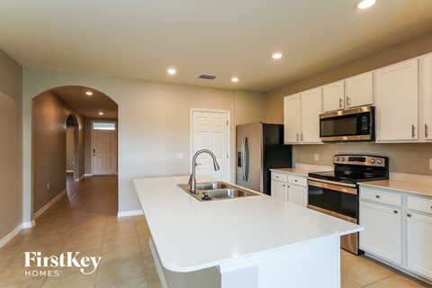 a kitchen with a large white counter top and a sink