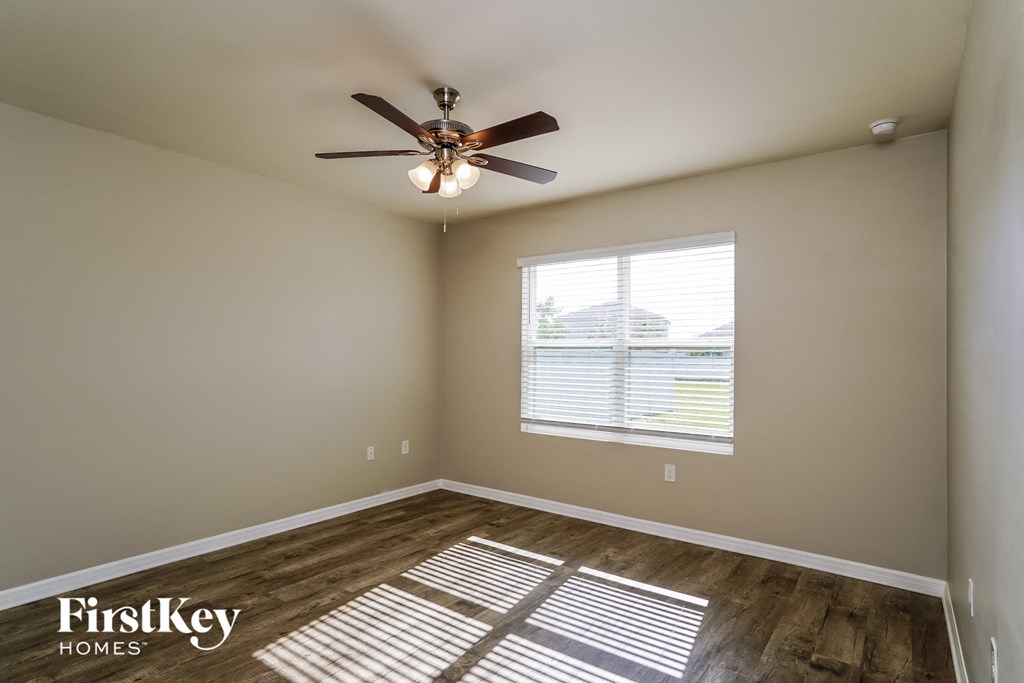 a bedroom with a ceiling fan and a window