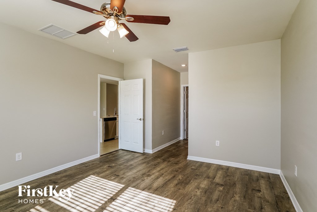 a living room with wood flooring and a ceiling fan