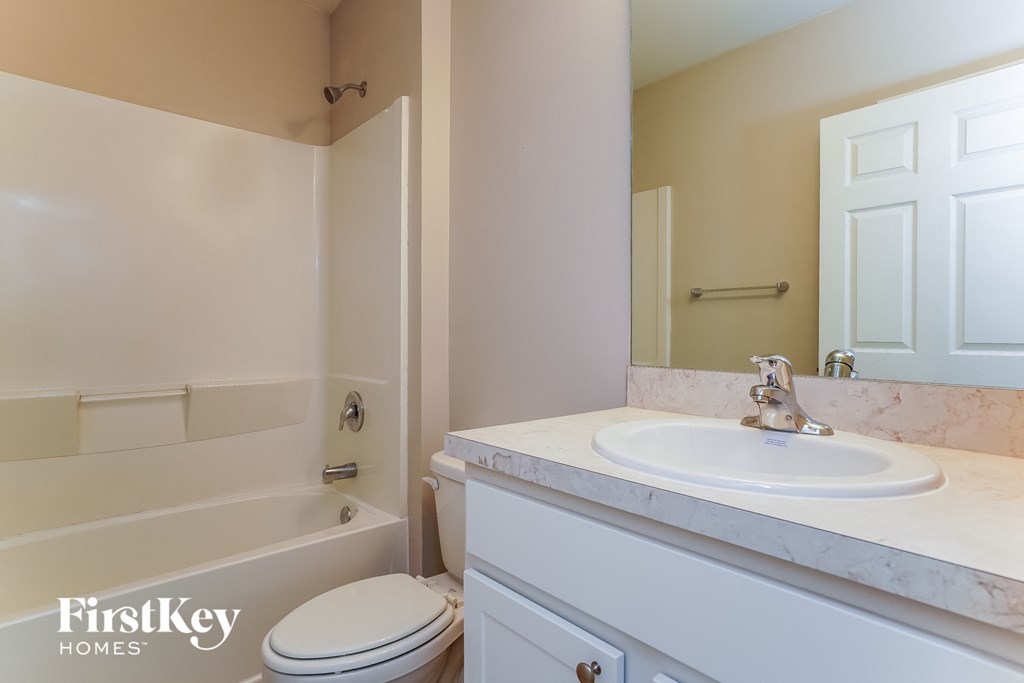 a bathroom with a sink and a toilet and a bath tub