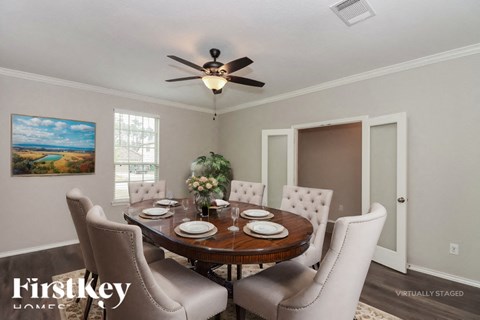 A dining room with a wooden table set for six.