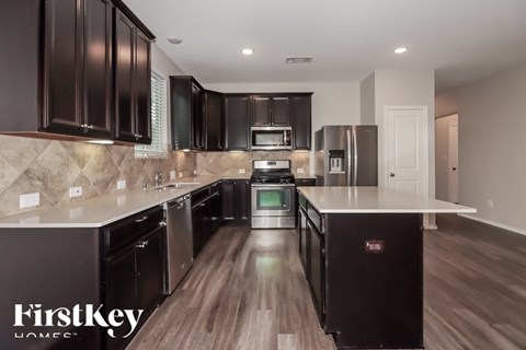 A modern kitchen with dark brown cabinets and a FirstKey logo.