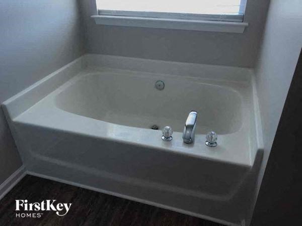 a white bath tub in a bathroom with a window