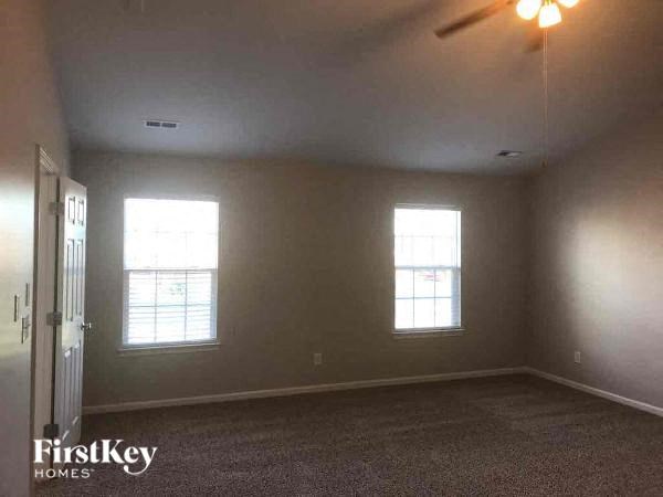 an empty room with two windows and a door