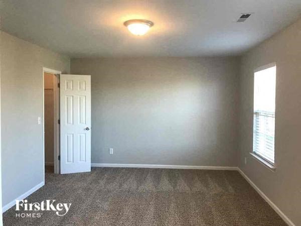 an empty room with a white door and a window