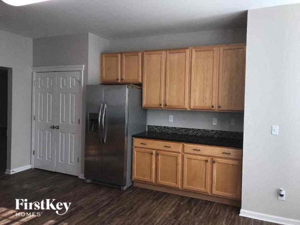 a kitchen with wooden cabinets and a stainless steel refrigerator