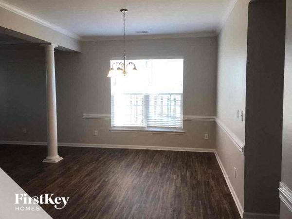 an empty living room with wood floors and a window