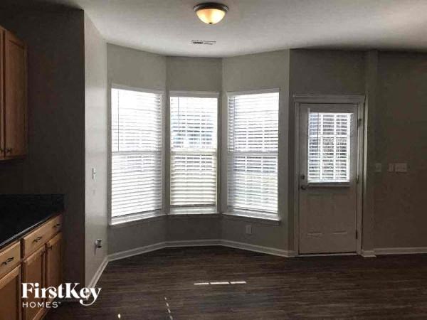 an empty living room with windows and a door