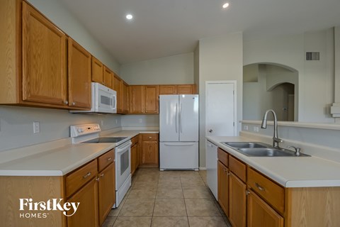 a kitchen with white appliances and wooden cabinets