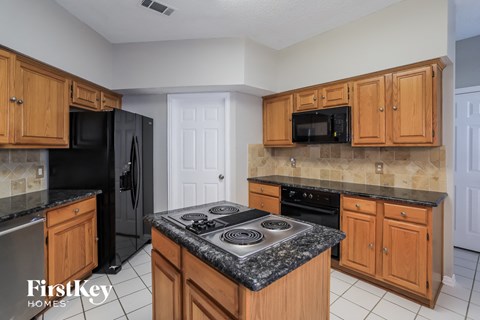 a kitchen with wooden cabinets and black appliances and granite counter tops