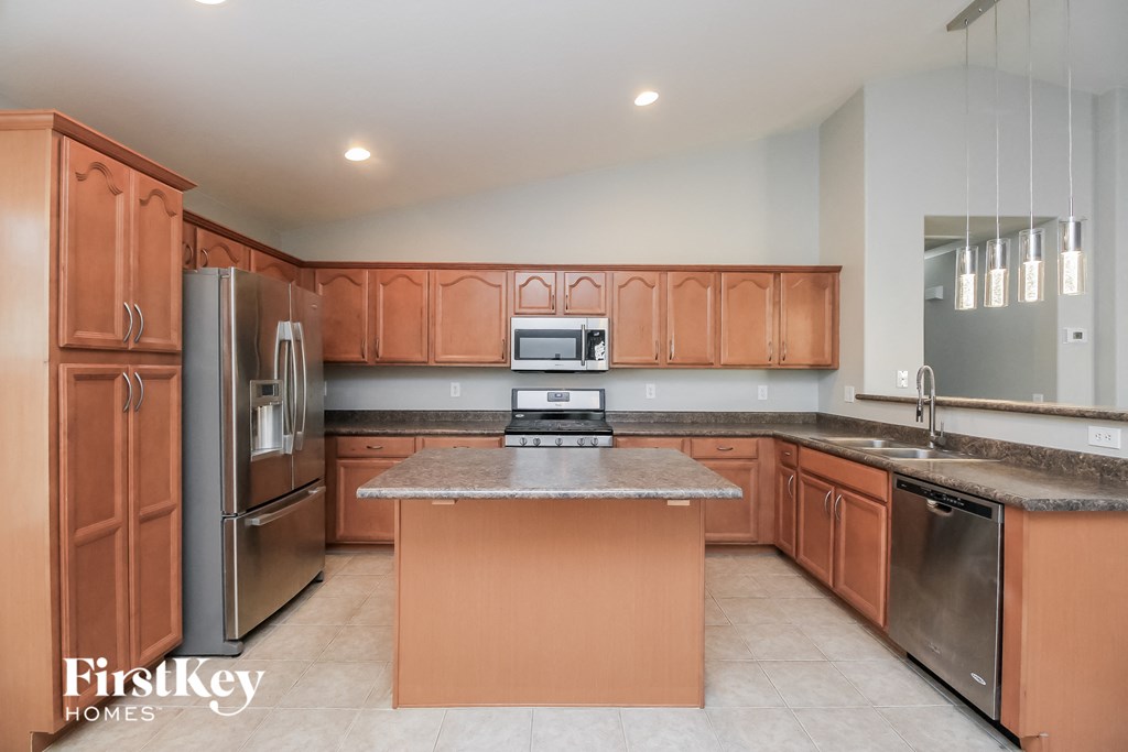 A kitchen with wooden cabinets and a marble countertop.