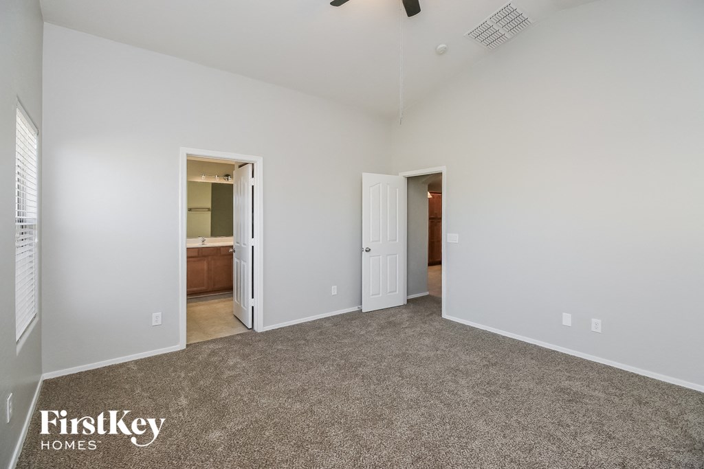 A spacious room with a carpeted floor and two open doors.