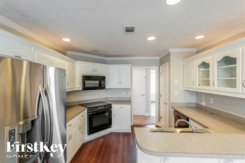 A kitchen with white cabinets and a stainless steel refrigerator.