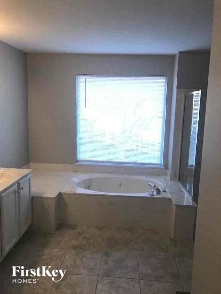 A bathroom with a tub and a window.
