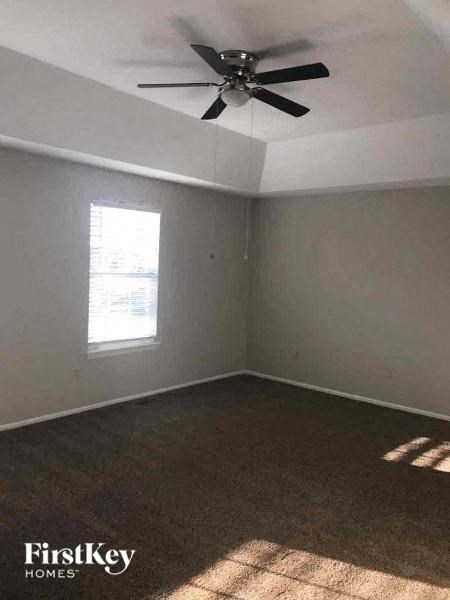 A room with a ceiling fan and a window.