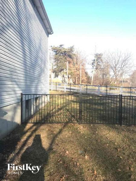 A metal fence in front of a house with the words "FirstKey Homes" on the bottom.