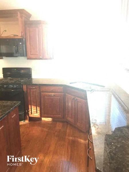A kitchen with wooden cabinets and a black stove top oven.
