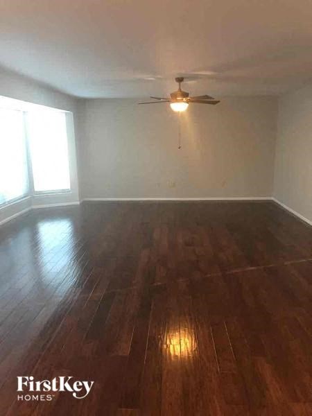 A room with wooden floors and a ceiling fan.
