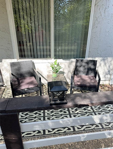 a patio with two chairs and a table