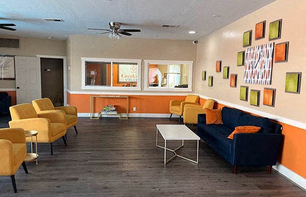 a living room with a blue couch and yellow chairs