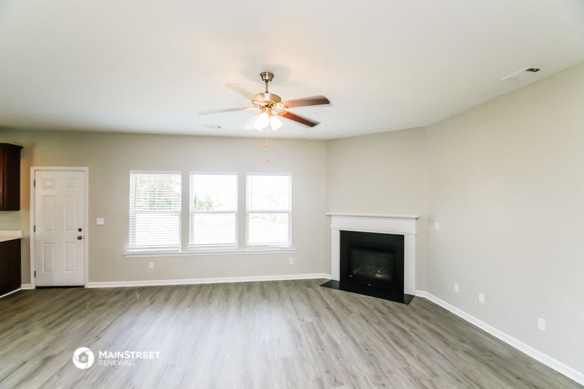 the living room with fireplace and ceiling fan