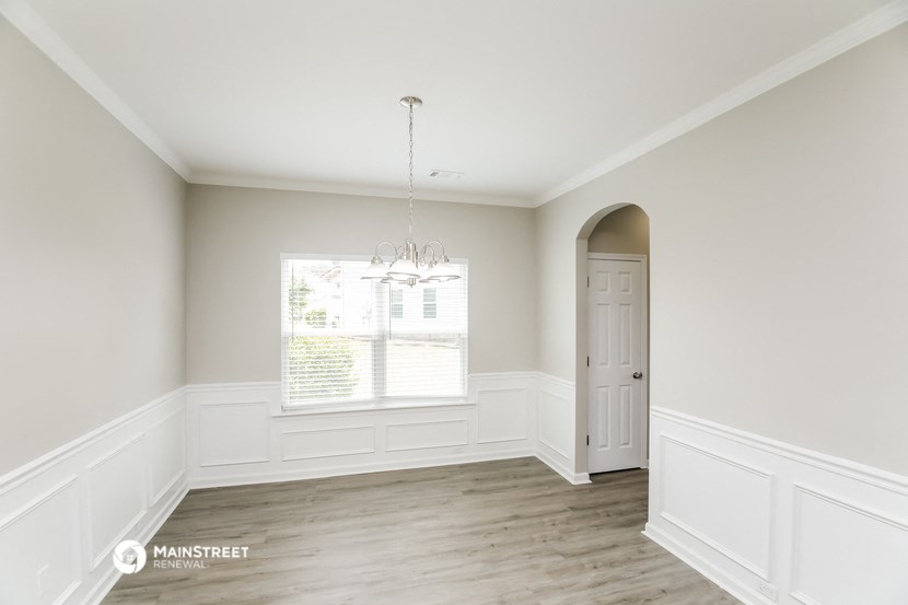 an empty living room with white walls and a white door