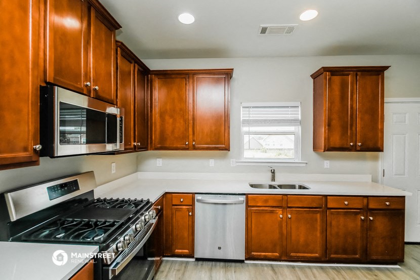 a kitchen with wooden cabinets and a stove and a microwave