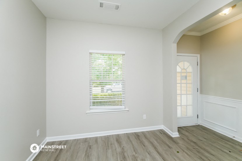 the living room of a new home with white walls and wood floors
