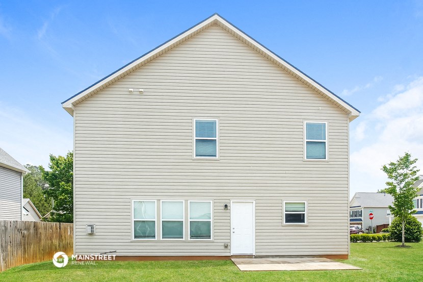 side view of a white house with white siding and a white door