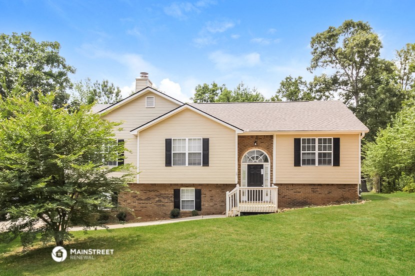a yellow house with a grassy yard and a tree