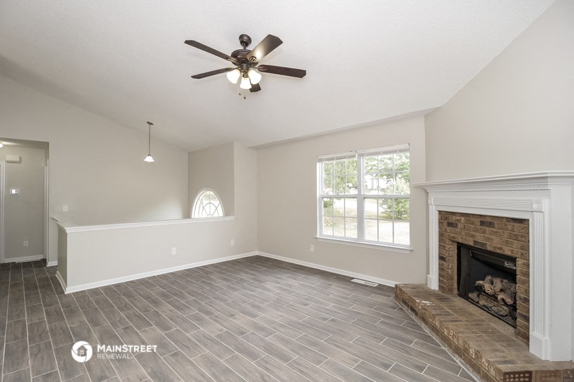 the living room with fireplace and ceiling fan