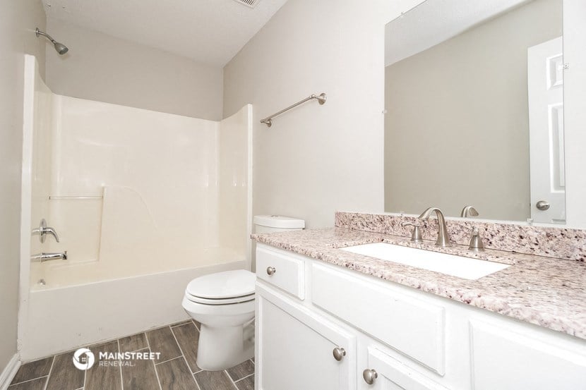 a bathroom with white cabinets and a sink and a toilet