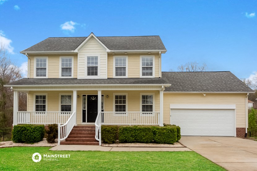 a yellow house with a porch and white doors