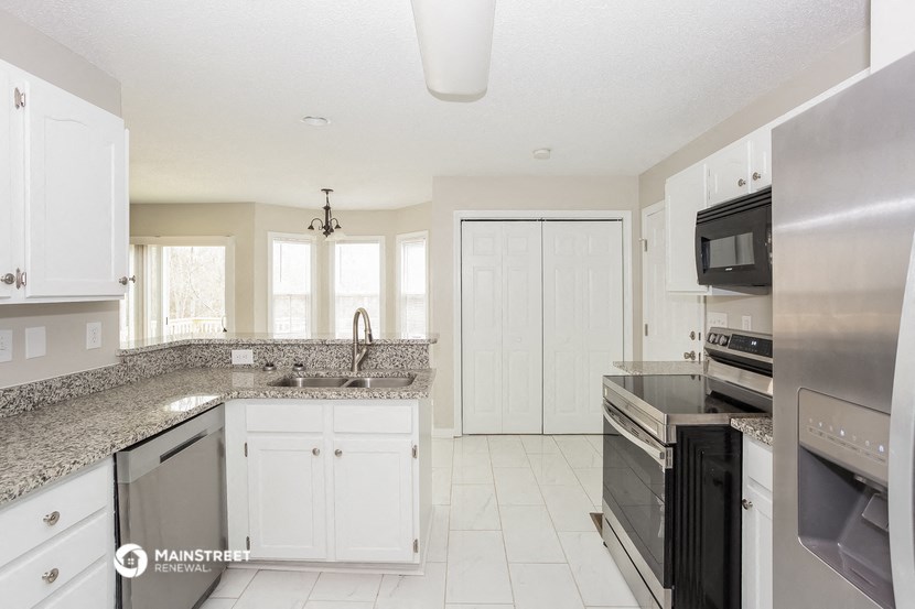 a kitchen with granite counter tops and white cabinets