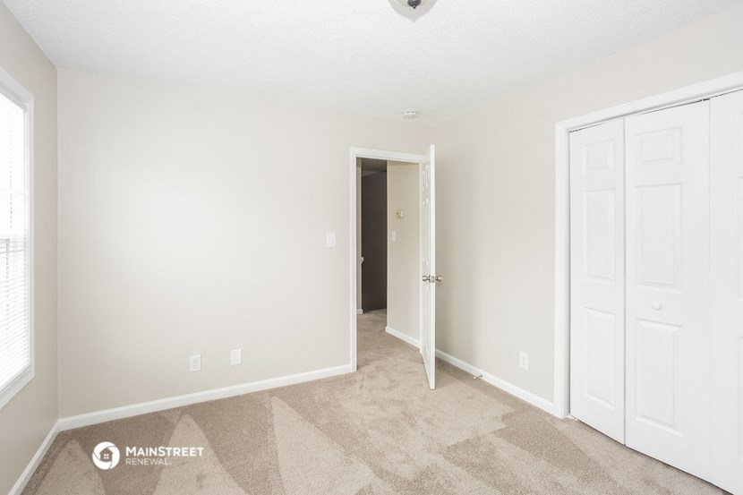 a bedroom with two closets and a door to a hallway