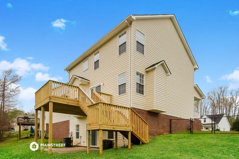 a yellow house with a deck on the side of it