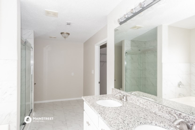 a bathroom with a sink and a mirror and a shower