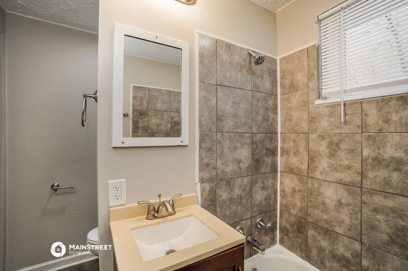 a bathroom with a sink and a shower and a mirror