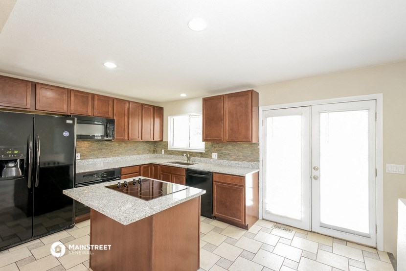 a kitchen with wood cabinets and black appliances and a counter top