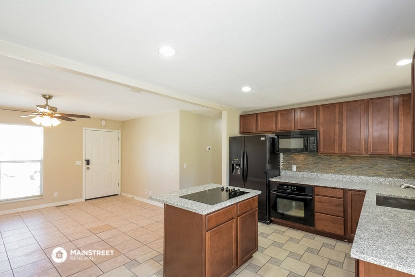 a kitchen with wooden cabinets and a black refrigerator